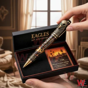 Hands holding an open eagles anniversary pen gift set featuring a detailed eagle themed pen and a commemorative card.
