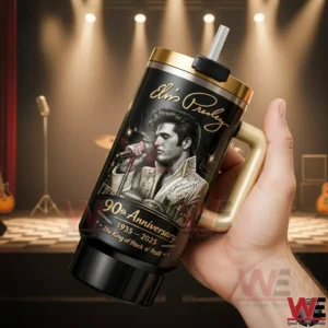 Hand holding a black and gold Elvis Presley anniversary tumbler with portrait signature and ninety th anniversary years in a studio with stage lights!