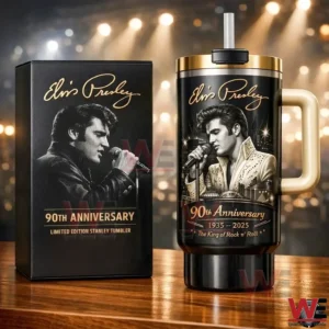 Black and gold Elvis Presley ninety th anniversary tumbler with portrait and signature beside a matching limited edition box on a wooden table with glowing stage lights!