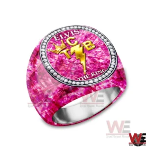 Elvis Presley TCB The King of Rock n Roll Luxury Ring 4 A pink gemstone patterned ring with an oval face that reads ELVIS and THE KING and features a gold TCB crown and lightning bolt emblem surrounded by a diamond like border on a white background!