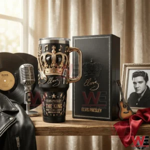 Black handled tumbler with gold crown and music themed embossed design beside a black gift box with crown artwork on a table with vintage music props!