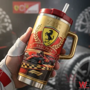 Ferrari Cavallino Rampante Tumbler 3 Hand holding a gold and red prancing horse racing themed tumbler with handle and straw against a blurred motorsport background!