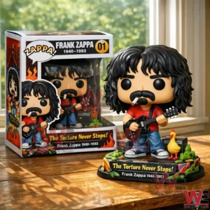 Frank Zappa collectible figure with guitar and themed base shown beside the product box on a wooden table!
