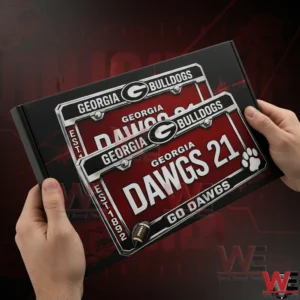 Hands holding a Georgia Bulldogs license plate with Dawgs 21 Go Dawgs text and team logo over a black gift box background!
