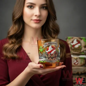 Woman holding a Ghostbusters anniversary glass with amber drink!