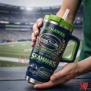 Seattle Seahawks Go Hawks 50th Anniversary Lumen Field Tumbler 3 Hands holding a dark blue and green Seattle Seahawks fiftieth anniversary tumbler with handle and straw with a blurred football stadium background!