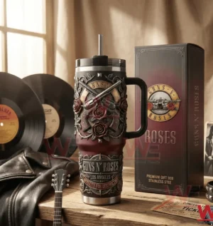 Guns N Roses insulated tumbler with handle and straw next to a matching gift box on a wooden table with vinyl records leather jacket guitar and concert tickets in the background!