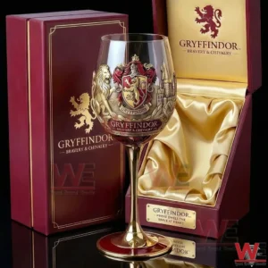 Harry Potter Gryffindor Houses Bravery Chivalry Goblet Glass 3 A Gryffindor wine goblet with gold stem positioned in front of an open decorative box emphasizing elegant design and premium presentation!