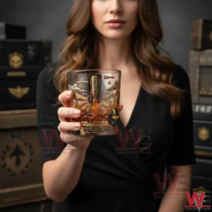 A person holding a Helldivers anniversary whiskey glass with detailed military themed artwork!