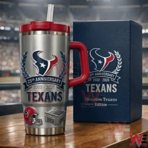Silver Houston Texans twenty fifth anniversary insulated tumbler with red handle and straw next to a navy collector box on a wooden table with a stadium background!