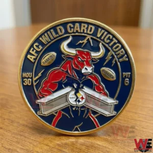 A navy and gold AFC wild card victory coin on a wooden surface showing a red bull mascot steel beam design and football score details in a bold collectible style