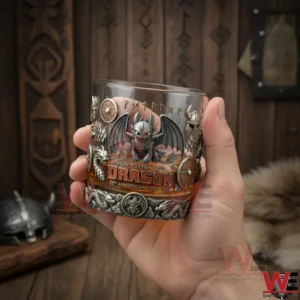 Hand holding a How To Train Your Dragon anniversary whiskey glass with dragon design and fantasy themed details!