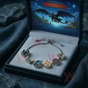 Silver adjustable charm bracelet in a dark gift box featuring How To Train Your Dragon artwork with dragon wing flame helmet and emblem charms.