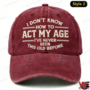 I Don't Know How To Act My Age I've Never Been This Old Before Embroidery Cap 9 A burgundy baseball cap with detailed embroidered text conveying a funny age themed message shown from the front on a white background!