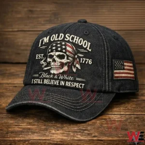 Close up of a black denim baseball cap with a skull wearing an American flag bandana and old school text plus a United States flag patch on the side.