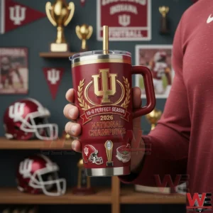 An Indiana Hoosiers tumbler with championship graphics is held at chest height against a background of trophies banners and team history!