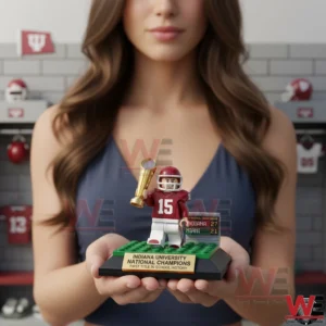 A small football champion figure with a trophy is held in both hands against a sports themed indoor background!