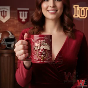 A woman holding a red Indiana University national champions mug with college football themed decorations behind her!