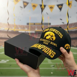 Iowa Hawkeyes Champions 2025 embroidered cap held beside a black presentation box with a stadium backdrop and celebratory flags!