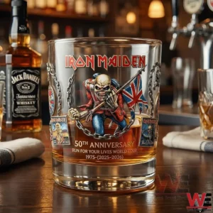 Iron Maiden anniversary whiskey glass on a bar counter featuring Eddie artwork chains and warm bar lighting!