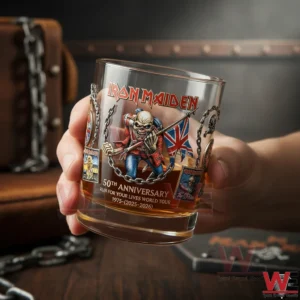 Hand holding an Iron Maiden anniversary whiskey glass with Eddie artwork and amber whiskey inside!