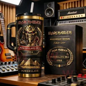 Black and gold insulated tumbler with handle and straw featuring Iron Maiden Powerslave era pharaoh skull artwork beside a matching collector box on a studio desk with guitars and audio gear in the background!