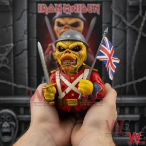 Iron Maiden Trooper Eddie Rubber Duck 5 Hands holding a yellow trooper rubber duck figure in a gray helmet and red uniform with a sword and a United Kingdom flag in front of an Iron Maiden poster!
