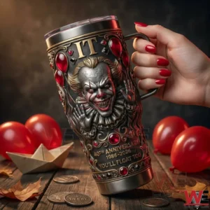 A person holding a horror inspired insulated tumbler with a sculpted clown face ornate details and red accents against a dark background!