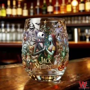 Decorated whiskey glass with Jack Skellington and Sally illustrated in a festive spooky style on a bar table!