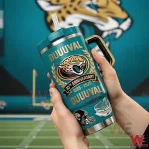 Hands holding a teal Jacksonville Jaguars Duuuuval tumbler with handle and straw showing Jaguars logo laurel wreath and 30th anniversary 1995 2025 text with a large Jaguars logo background