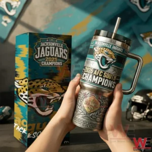 Hands holding a Jacksonville Jaguars themed stainless steel tumbler with handle and straw showing 2025 AFC South Champions text beside a Jacksonville Jaguars 2025 Champions gift box in a team themed room!