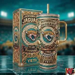 A Jacksonville Jaguars themed insulated tumbler with intricate patterns and team branding stands next to its matching box on a reflective surface inside a football arena!
