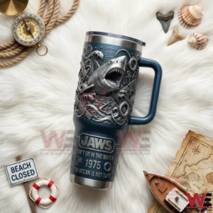 Blue handled tumbler with embossed shark and ocean wave details on white fur surrounded by rope compass shells beach closed sign and nautical props!