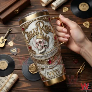 A hand holding a Jelly Roll insulated tumbler above a wooden table with music memorabilia!