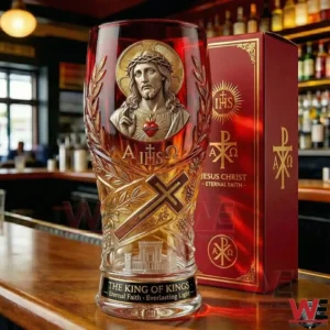 A red and gold religious glass with an image of Jesus Christ sacred heart cross and ornate details placed on a bar with a matching decorative box in the background!