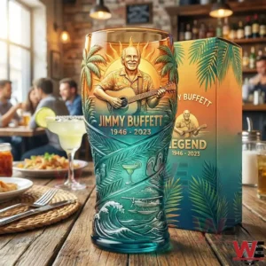 Jimmy Buffett tribute glass with tropical design placed on a restaurant table with food drinks and people in the background!