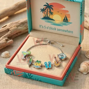 Silver adjustable charm bracelet in a teal and coral gift box with tropical sunset design and Its five oclock somewhere message plus cocktail parrot island flip flops guitar and compass charms.