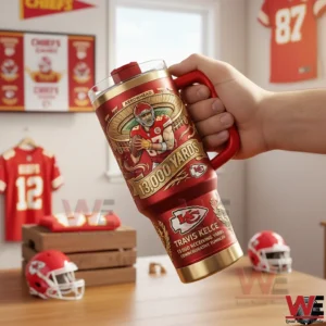 Red Kansas City Chiefs tumbler with handle and straw showing Arrowhead Stadium art football player and 13000 yards text held in a room with Chiefs jerseys and fan decor.
