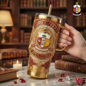 Hand holding a red and gold fraternity themed metal tumbler in front of books and elegant decor!