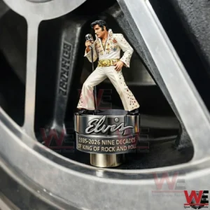 Elvis themed tire valve cap with a miniature singer figurine in a white jumpsuit standing inside a close up car wheel rim!