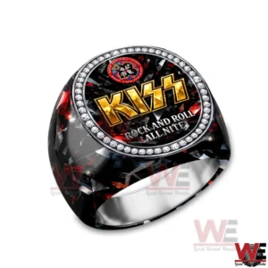 Close up of a KISS ring featuring the gold KISS logo and Rock and Roll All Nite text framed by a ring of clear stones.