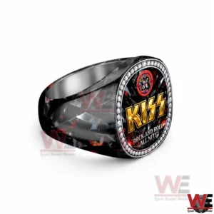 Side view of a KISS luxury ring showing the patterned band and the oval face with the gold KISS logo and sparkling stone border.
