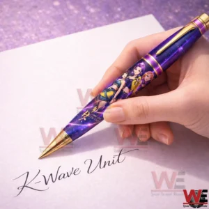 Hand holding a purple galaxy themed K Wave Unit pen with character artwork above a white sheet where K Wave Unit is written in cursive.