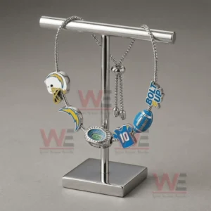 Silver adjustable charm bracelet with LA Chargers helmet lightning bolt stadium number ten football and Bolt Up charms hanging on a metal display stand.