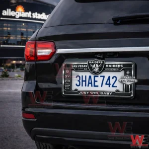 Rear view of a black SUV showing a Las Vegas Raiders license plate frame with the number 3HAE742 and the phrase Just Win Baby near Allegiant Stadium!