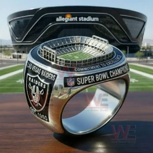 A Las Vegas Raiders ring with an Allegiant Stadium model on top and side text reading Super Bowl Champions and Las Vegas Raiders with a Raiders shield logo shown in a stadium setting!