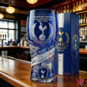 A blue Tottenham Hotspur anniversary beer glass standing on a bar with detailed club symbols and a matching presentation box in the background!