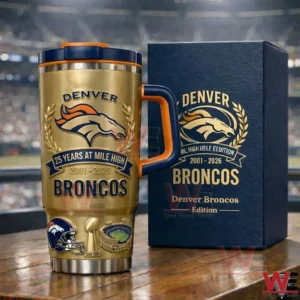 Gold Denver Broncos insulated tumbler with 25 years at Mile High 2001 to 2026 design beside a navy gift box on a wooden table in a football stadium background!