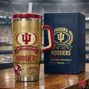 Gold Indiana Hoosiers anniversary insulated tumbler with red lid and handle beside a navy gift box on a wooden table!