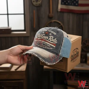 Vintage Living Legend Old Guys Rule cap with frayed brim and embroidered lettering held near a gift box in a rustic indoor background!